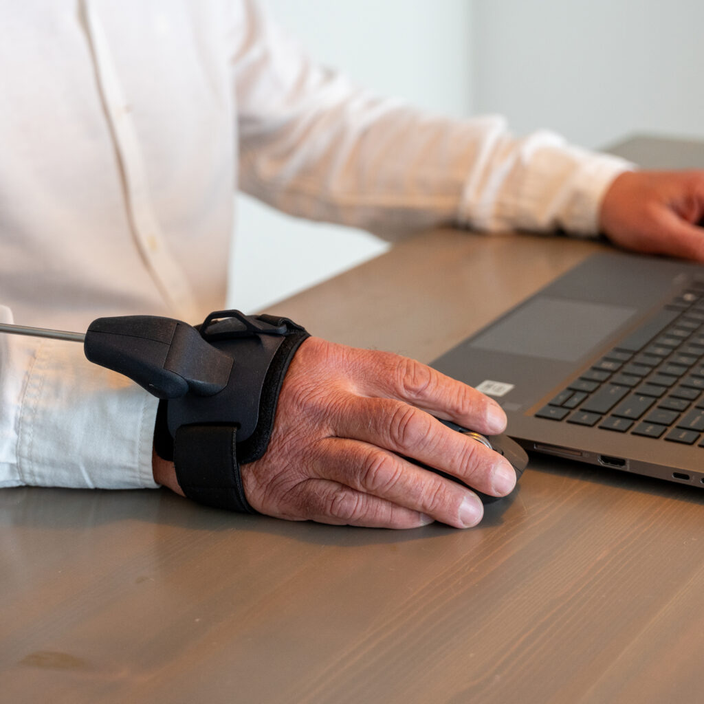 Dämpfen statt Fixieren: So funktioniert die Stil Hand Control™ bei Tremor 2 Hand, welche eine Maus bedient. Die Person trägt die Stilorthese - Stil Hand Control